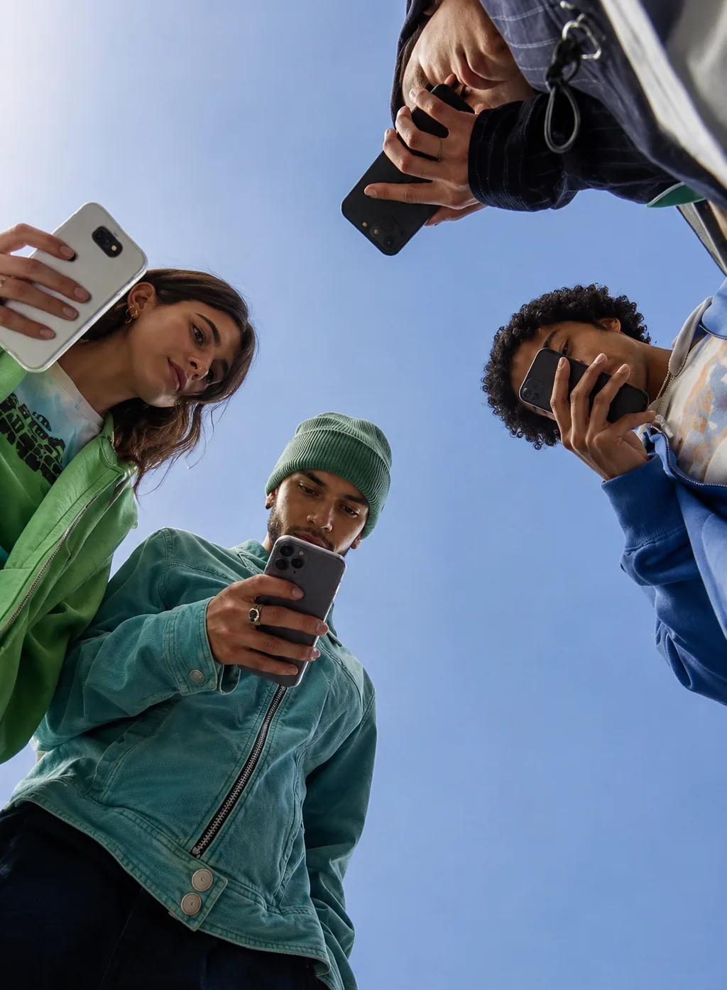 Four friends in a circle, everyone staring at their phone