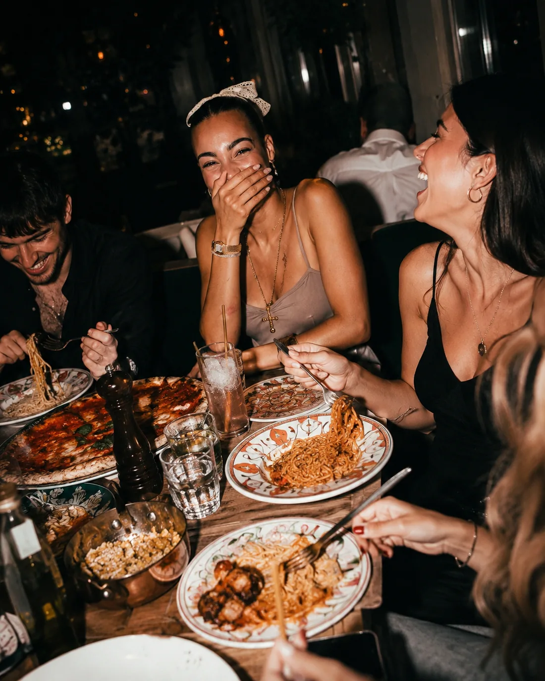 Friends at dinner, laughing over shared food