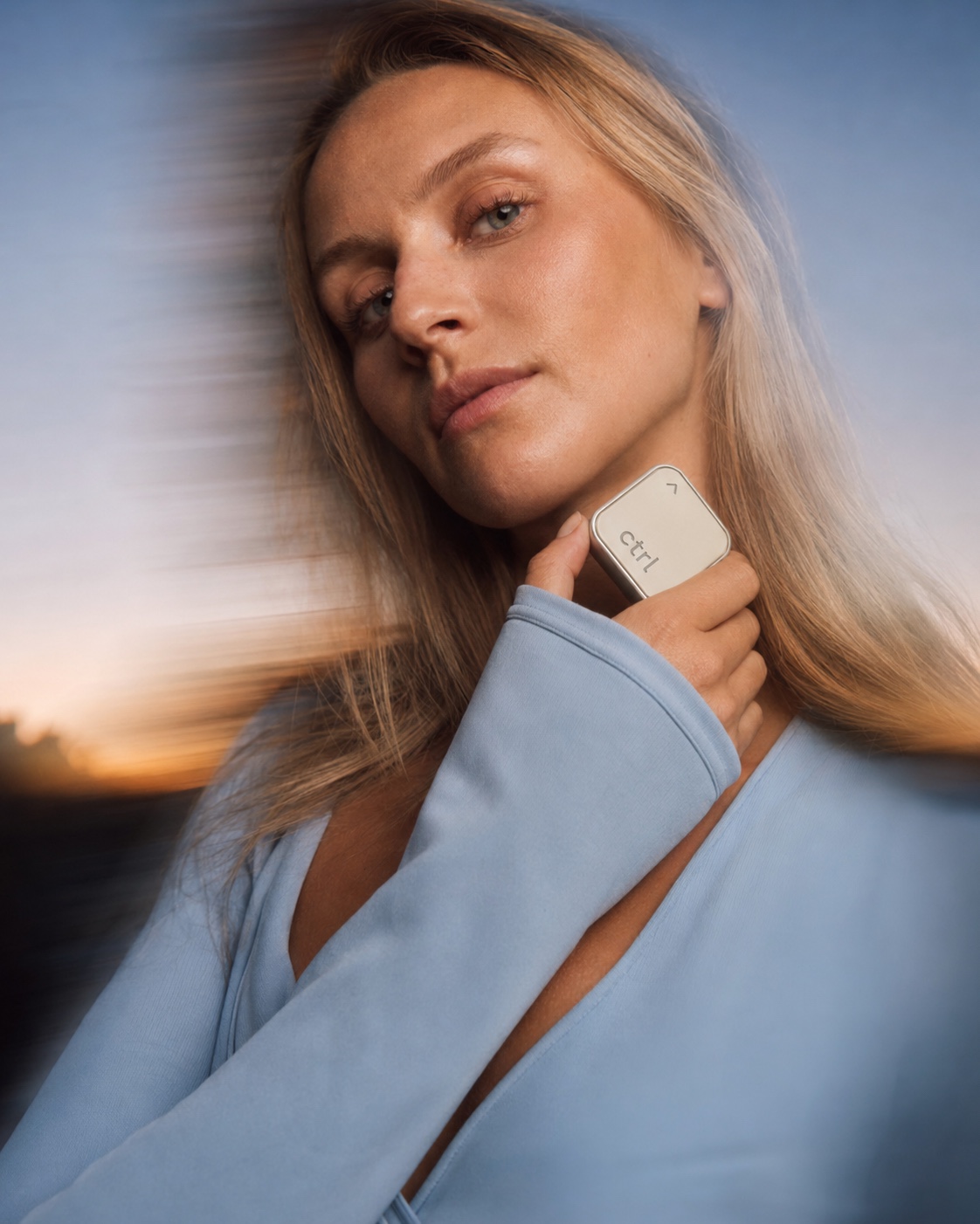 Woman at dusk holding the ctrl key gently against her cheek