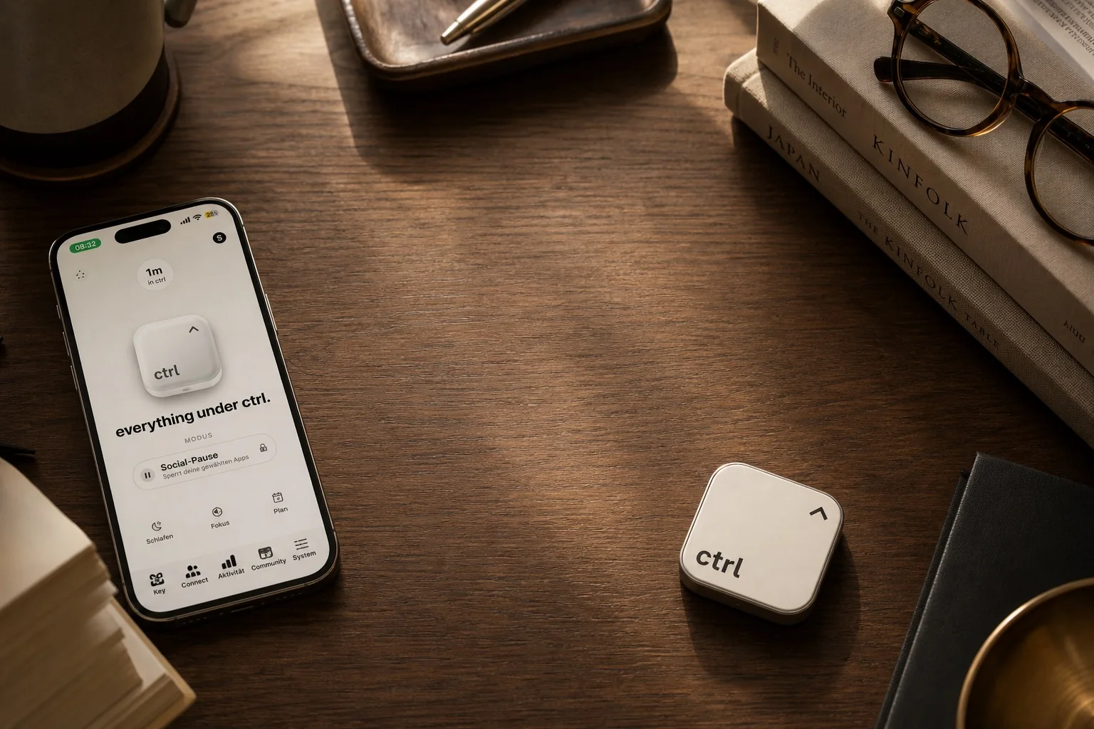 An iPhone with the ctrl app lying next to the ctrl key on a warm wooden desk